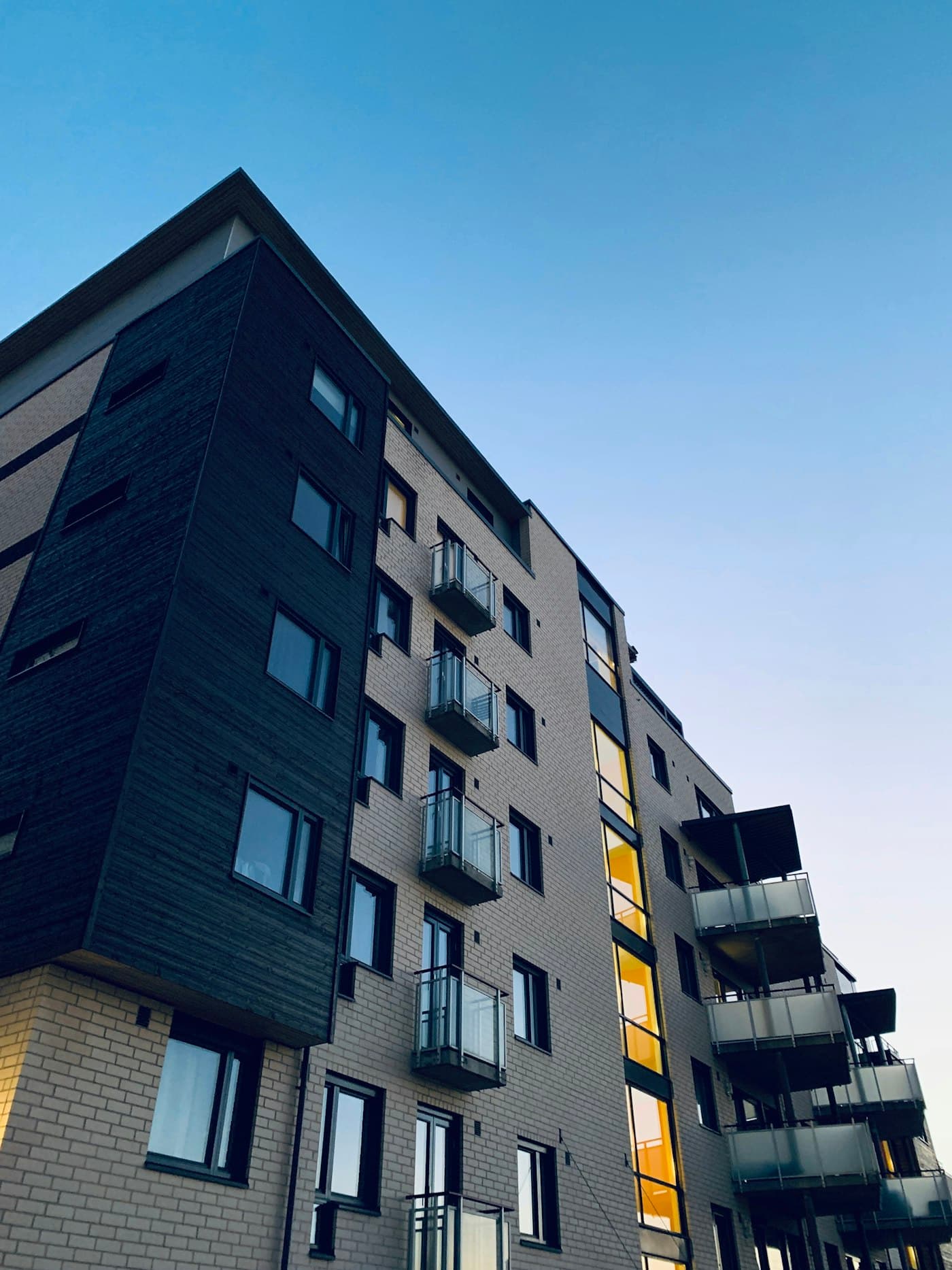 Moderna daudzdzīvokļu ēka ar balkoniem, skats no ielas